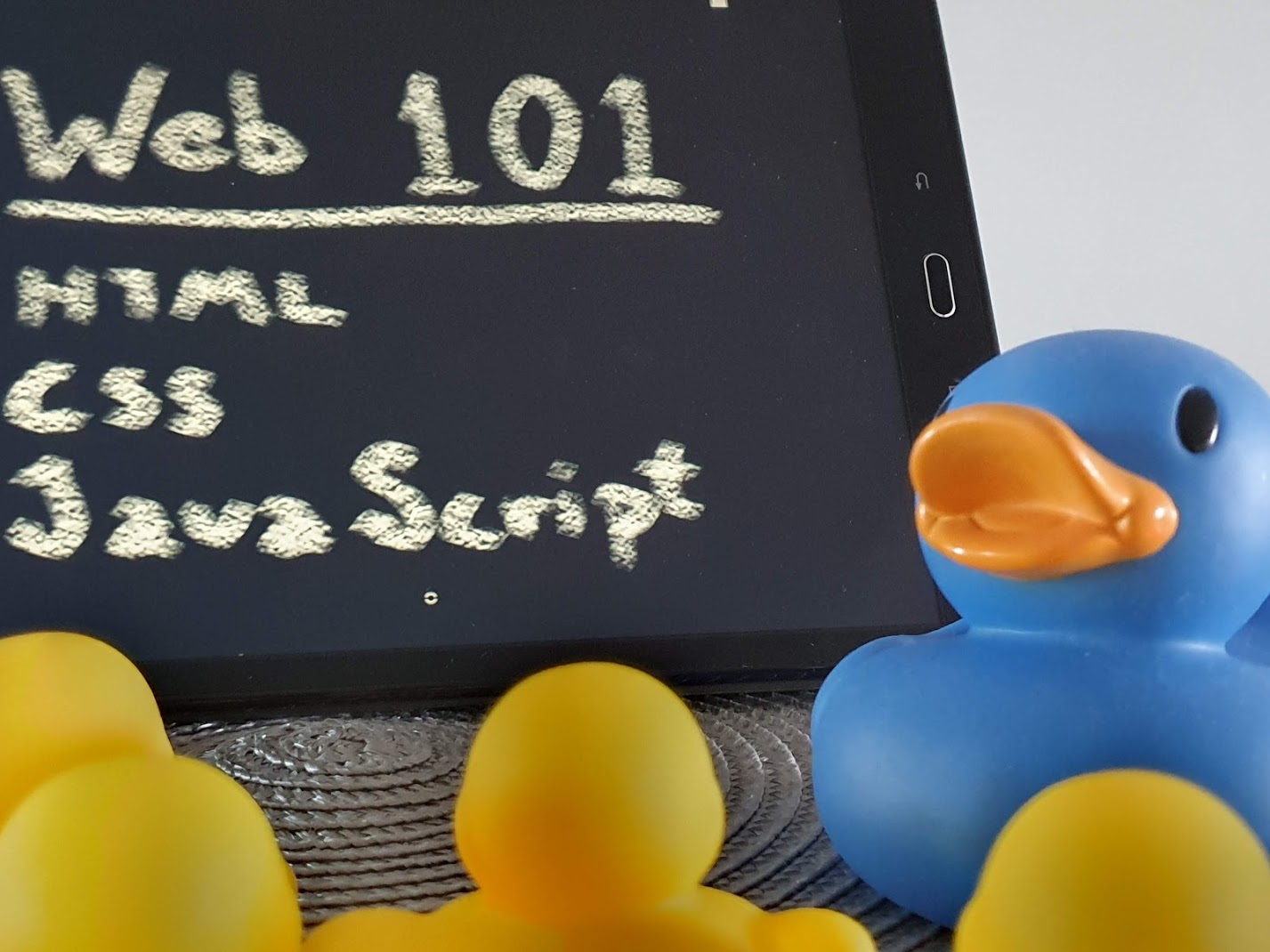 A big blue rubber duck teaching web development to smaller yellow rubber ducks